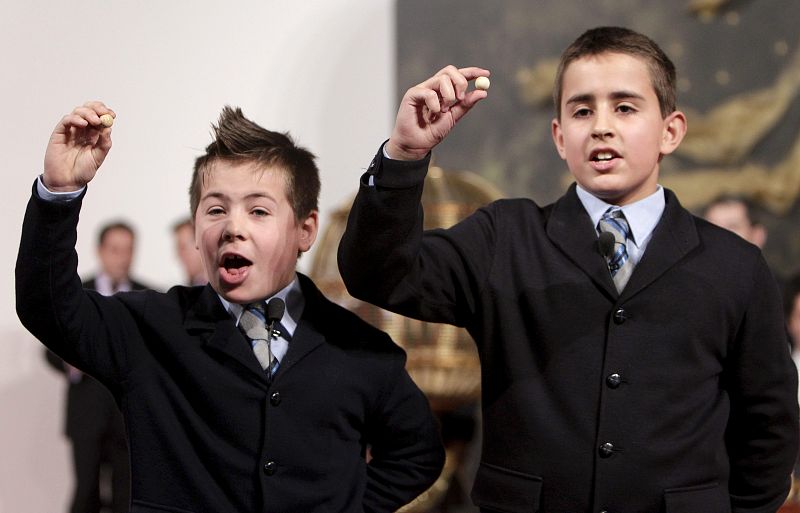 Los niños del Colegio de San Ildefonso Ivan Quintero y Andreas López muestran el número 79.250, que ha sido agraciado con el premio gordo de Navidad y se ha vendido en Alicante, Barcelona, Cáceres, Guipúzcoa, Madrid, Murcia, Palencia, Tenerife y Zara