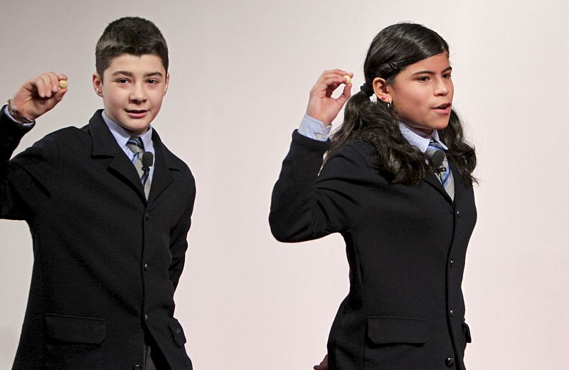 Los niños del Colegio de San Ildefonso Alfredo R. Grande y Marisel Carvajal muestran el número 75.913, agraciado con el tercer premio, que ha caído íntegramente en Madrd.