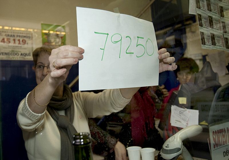 Una dependienta de la administración Nº97 de Barcelona muestra el número 79250, agraciado con el primer premio de la Lotería de Navidad.