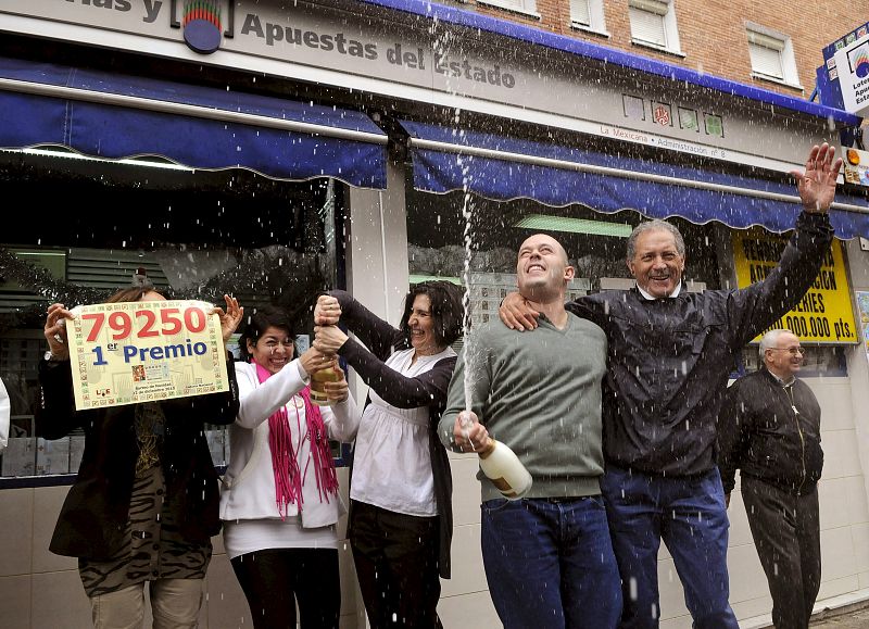 Los dueños de la administración de lotería número ocho de Alcorcón (Madrid) celebran la venta del número 79.250, primer premio en el sorteo extraordinario de Navidad.