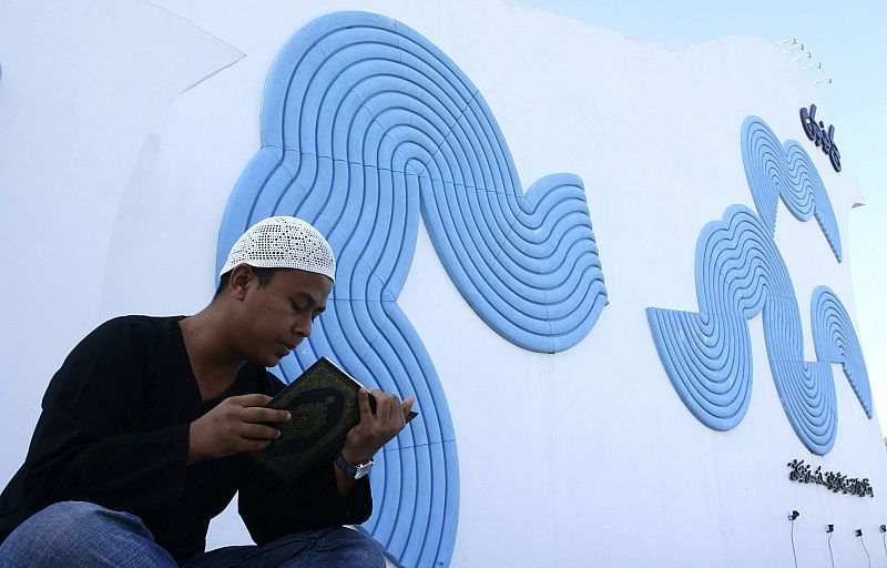 An Acehnese man prays for family members who died in the 2004 tsunami, at the Lambaro mass grave near Banda Aceh