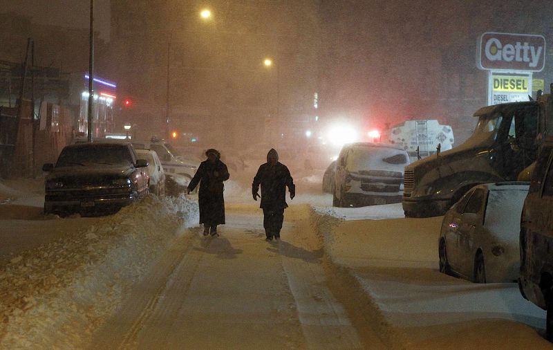 Gente andando esta madrugada en Brooklyn (Nueva York, EE. UU.) en plena tormenta de nieve