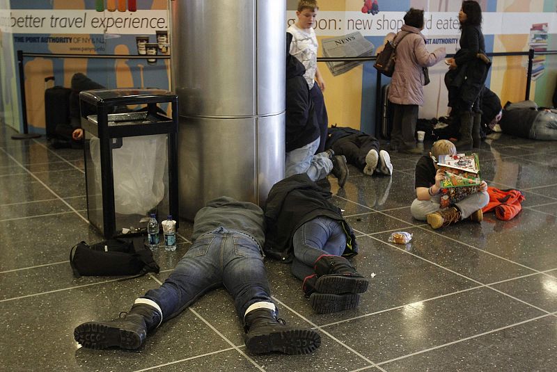 Pasajeros esperan durmiendo la reapertura del aeropuerto JFK