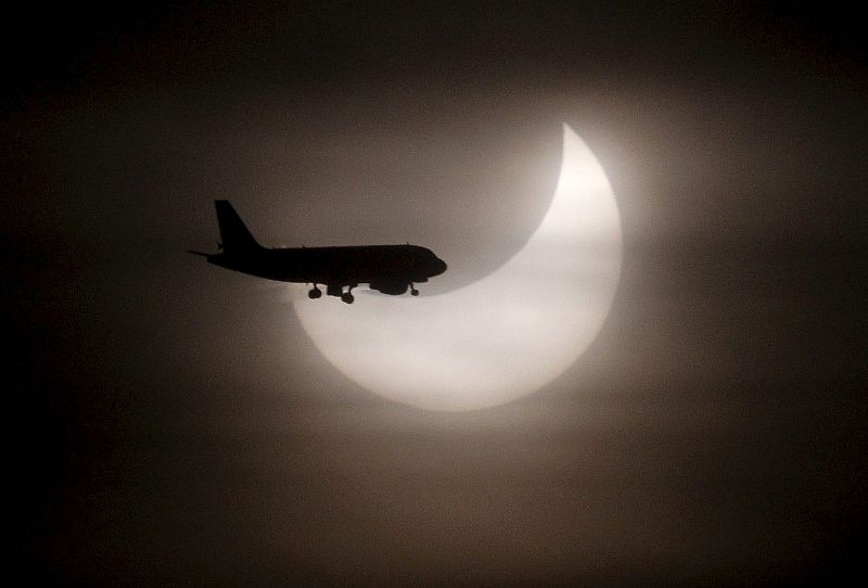 Un avión pasa ante el sol durante el eclipse solar parcial que se ha producido a primera hora de esta mañana