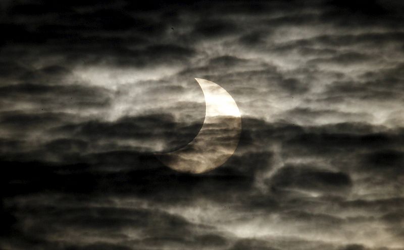 Las nubes no han impedido del todo que el eclipse se vea así desde Barcelona