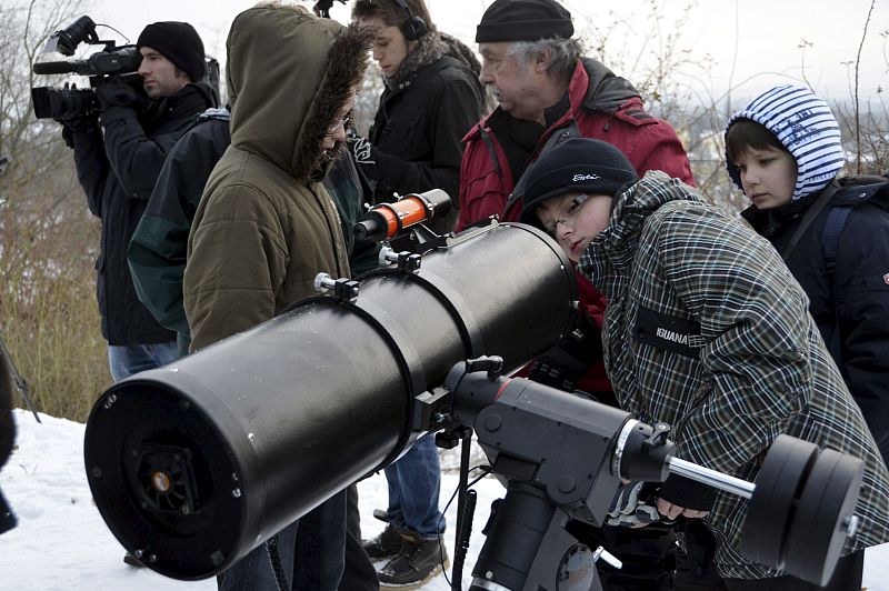 Aficionados miran por un telescopio para ver el aspecto del eclipse solar parcial que se ha producido a primera hora de esta mañana en Kassel (Alemania)