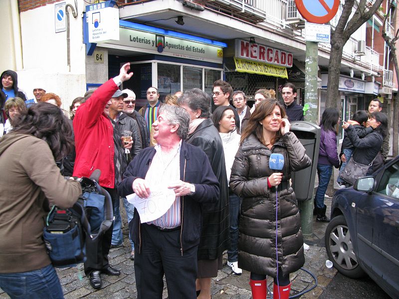 Los compañeros de TVE se preparan para realizar un directo frente a la administración que ha repartido el Gordo en Madrid.