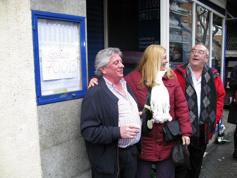 El lotero de la administración 247 de Madrid celebra con los vecinos el premio.