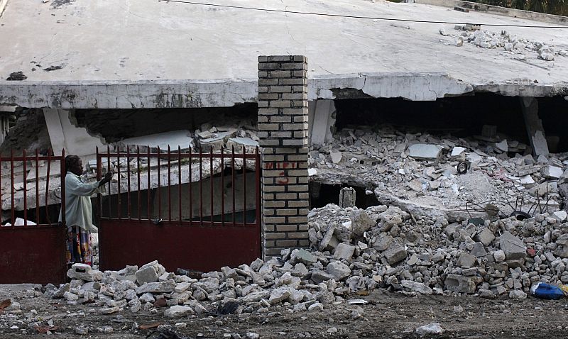 Una mujer haitiana observa las ruinas de su hogar, destruido por el terremoto de enero de 2010