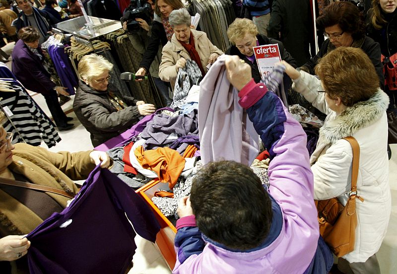 Numerosas personas revisan los artículos rebajados este viernes en un centro comercial en Madrid.