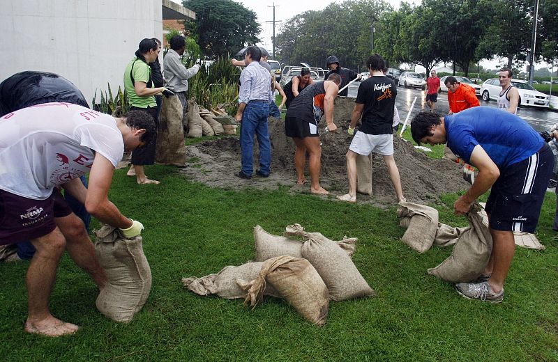 Vecinos de Brisbane en Australia colocan sacos de arena para proteger sus casas de las riadas