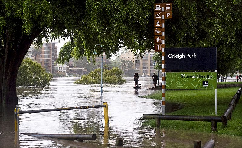 Los peatones caminan por el agua que cubre el parque Orleigh en el West End de Brisbane (Australia).