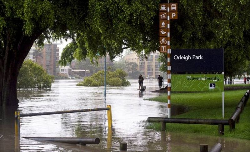 Los peatones caminan por el agua que cubre el parque Orleigh en el West End de Brisbane (Australia). 