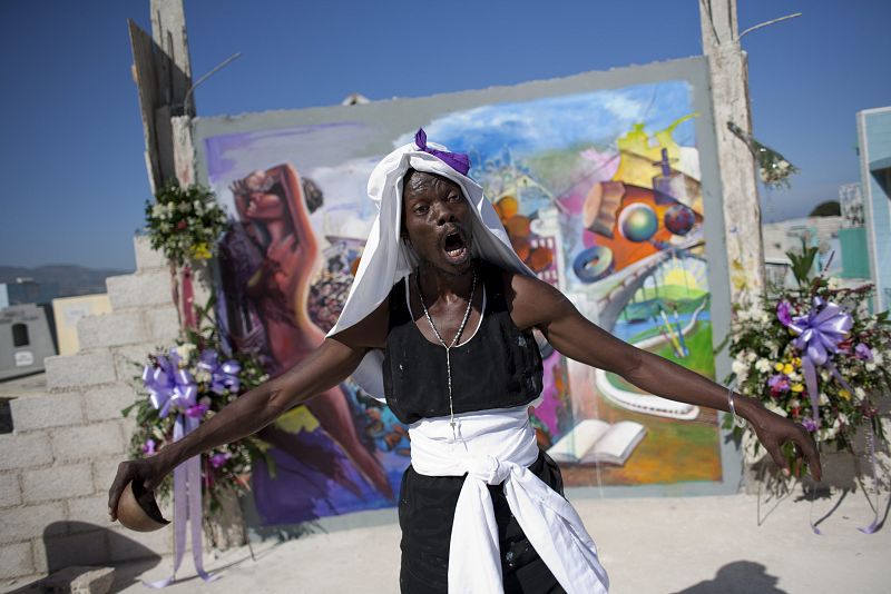 Un hombre canta en frente de un mural como tributo a las víctimas en Puerto Príncipe.