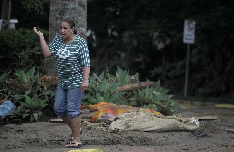 Un mujer camina entre los cadáveres de las víctimas de las intensas lluvias.