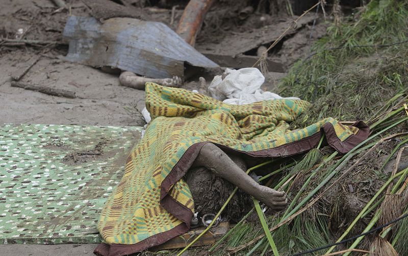 Los cuerpos de las víctimas son apilados entre el lodo por los propios vecinos.
