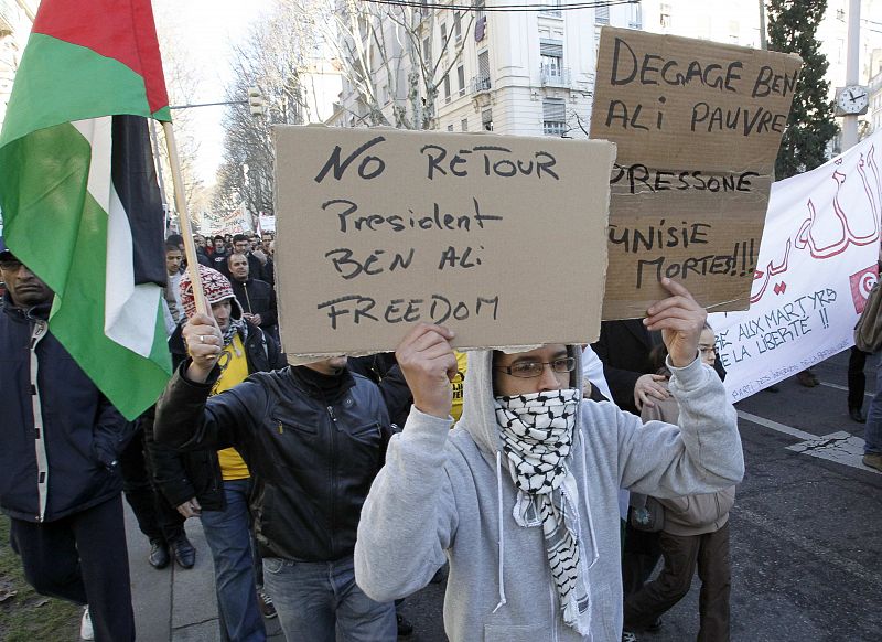 Tunisian and Algerian people living in France hold a banner which reads "Ben Ali No return" as they demonstrate in Lyon