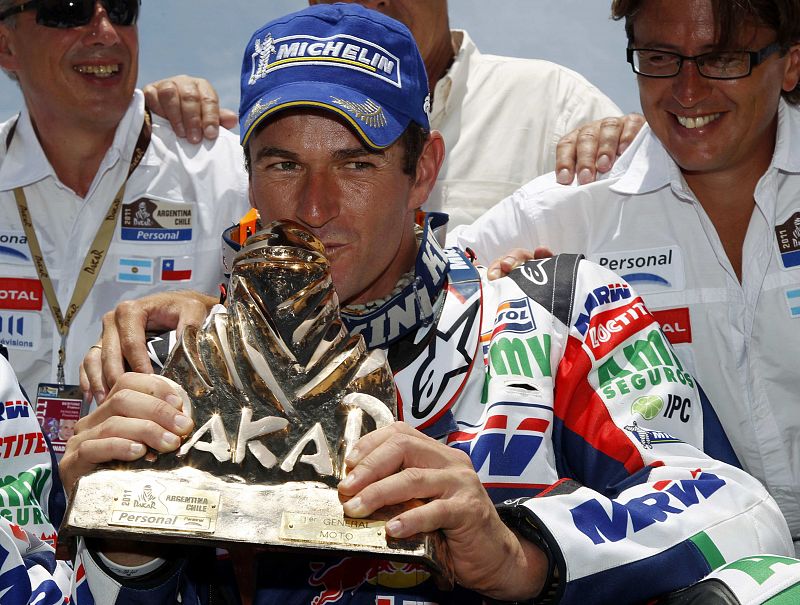 Marc Coma besa el trofeo que le acredita como ganador del Dakar 2011.