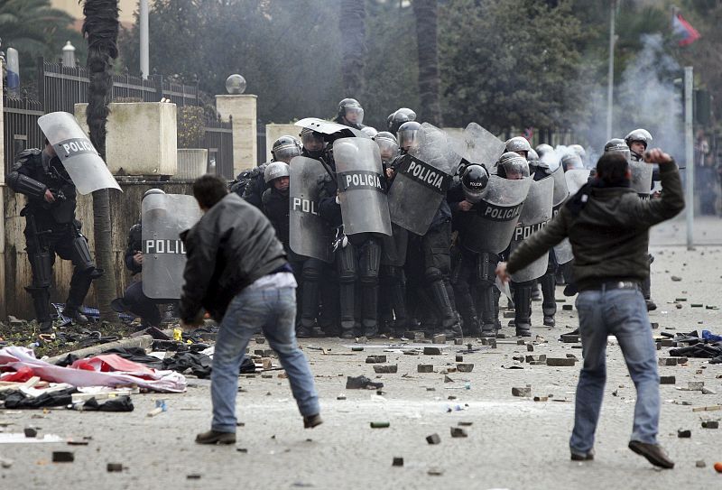 Varios manifestante lanza piedras a los policías antidisturbios durante la manifestación en Tirana