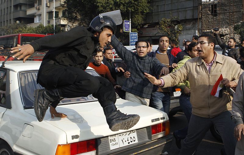 Un policía salta sobre un coche durante la protesta antigubernamental en el centro de El Cairo.