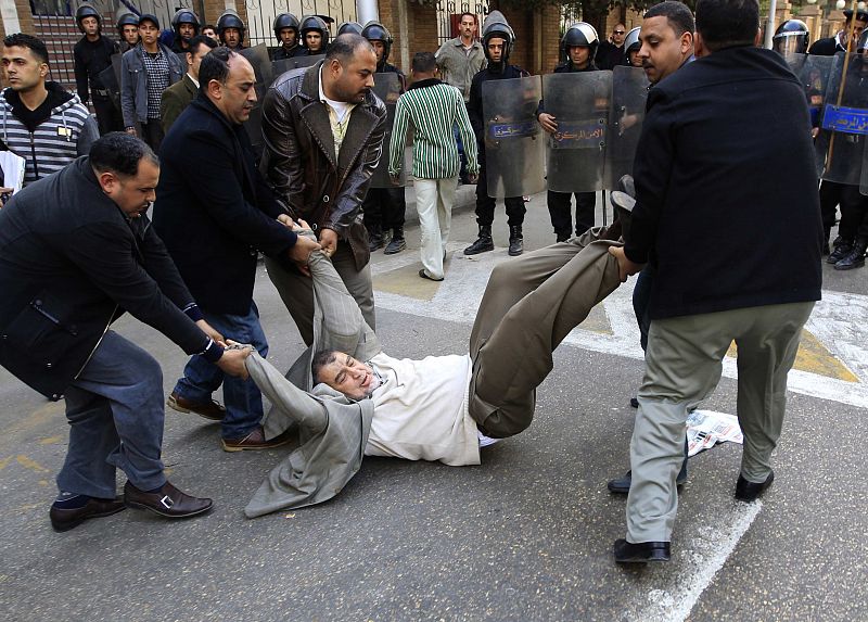 La policía vestidos de civil detienen a un manifestante durante los enfrentamientos en El Cairo.