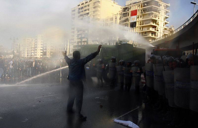 A protester stands in front of riot police and a water cannon outside a mosque after Friday prayers in Cairo