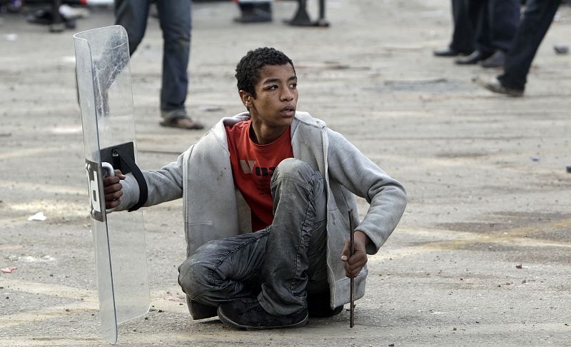 An Egyptian anti-government protester shields himself during clashes with riot police at Tahrir Square in downtown Cairo