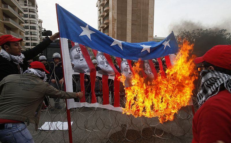 Protesters burn a flag with images of Egypt's President Mubarak during a sit-in organised by Lebanese activists in front of the Egyptian embassy in Beirut