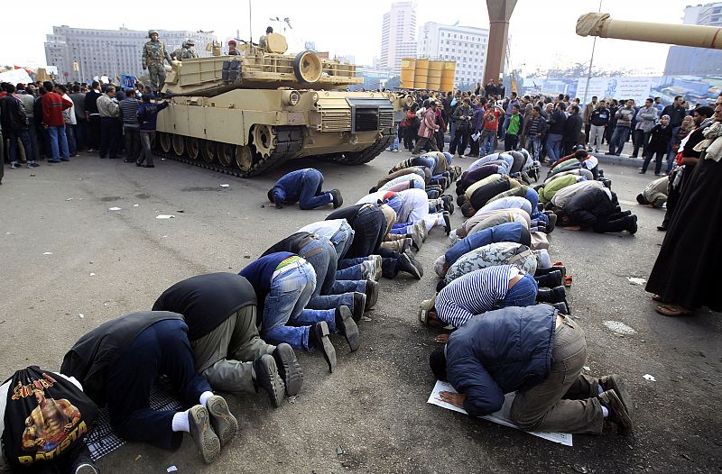 Protesters pray near Egyptian Army tanks in Cairo