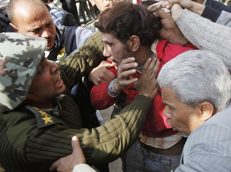 Army members and people detain a thief in downtown Cairo