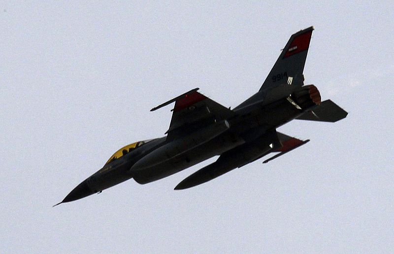 An Egyptian air force fighter plane flies low over thousands of anti-government protesters gathered at Tahrir square in Cairo