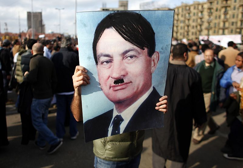 Un hombre porta una foto del presidente egipcio, Hosni Mubarak, con un bigote dibujado al estilo de Hitler. (31/1/2011).