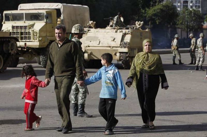 Una familia pasea cerca del Museo Egipcio, junto a varios soldados.