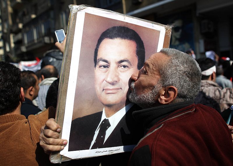 Un seguidor de Mubarak besa el retrato del presidente