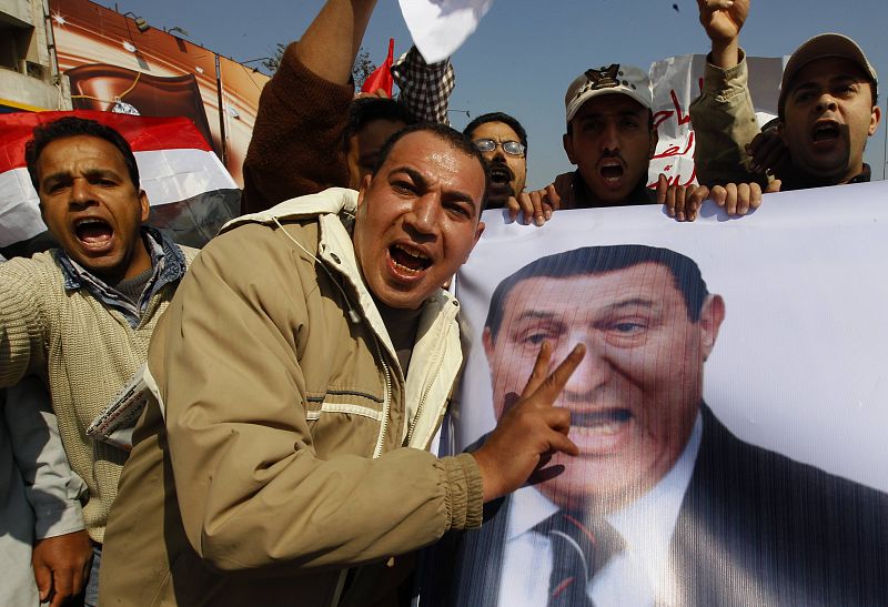 Un grupo de manifestantes porta un póster del presidente Mubarak