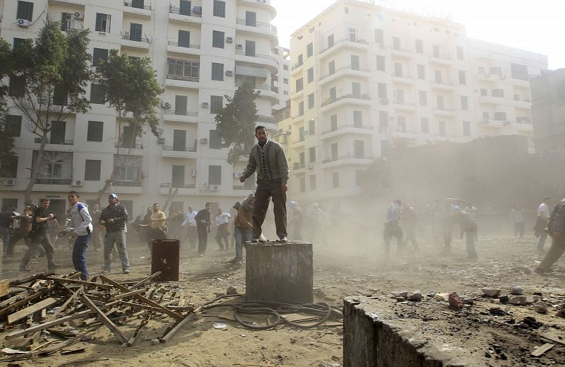 An opposition supporter throws stones at pro-Mubarak demonstrators in Tahrir Square in Cairo