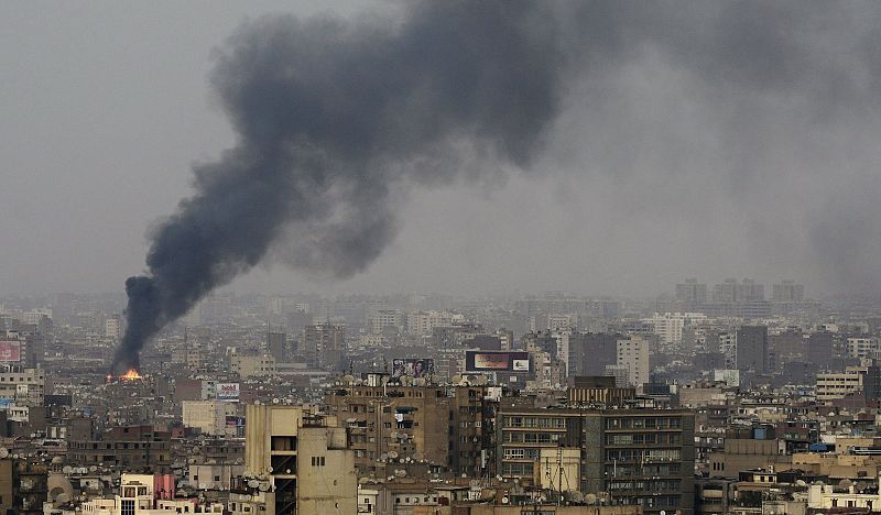 Una nube de humo se eleva por el cielo mientras las manifestaciones multitudinarias en contra del presidente egipcio Mubarak han provocado enfrentamientos en El Cairo.