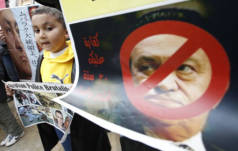 A young Egyptian resident in Japan stands between the banners during a rally in Tokyo