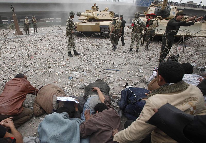 Opposition supporters lay down on the ground in front of Egyptian army tanks on the frontline near Tahrir Square in Cairo