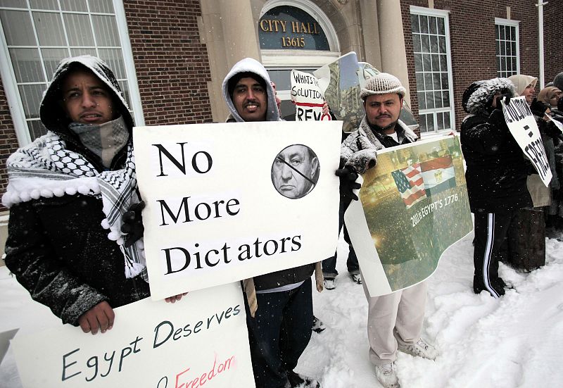 Egyptian-Americans stand in snow holding signs demanding Egypt's President Mubarak step down as they demonstrate in support of Egyptian protesters, in Dearborn