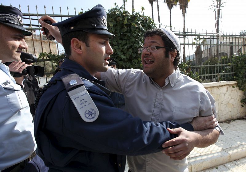 Un policía israelí discute con un colono judío que protesta ante la visita de la ministra española de Asuntos Exteriores