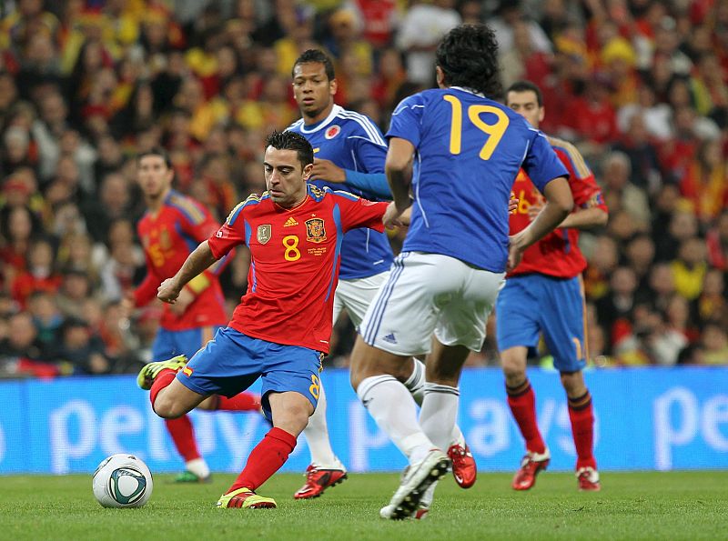 Xavi Hernández, con el balón ante Guarín y Abel Aguilar, de Colombia.