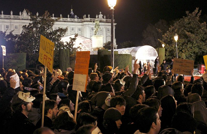 Varios cientos de personas convocados por el grupo "Anonymous", durante la concentración que han llevado a cabo en las inmediaciones del Teatro Real d