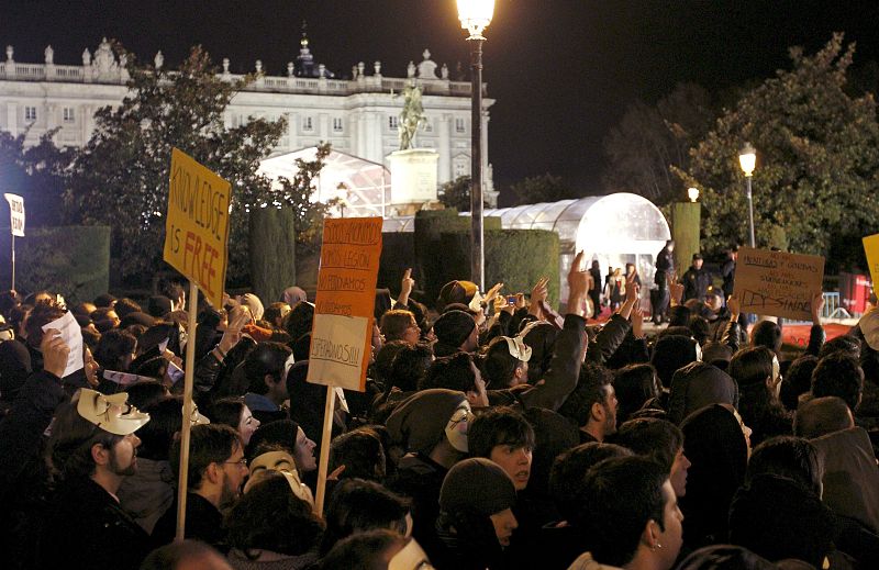 Varios cientos de personas convocados por el grupo "Anonymous", durante la concentración que han llevado a cabo en las inmediaciones del Teatro Real d
