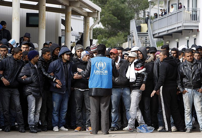 Un miembro de la Agencia de la ONU para los Refugiados habla con los inmigrantes ilegales tunecinos en el Centro de Acogida de Lampedusa.an island of Lampedusa