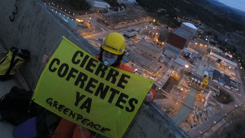 Un activista de Greenpeace muestra un cartes pidiendo el cierre de Cofrentes