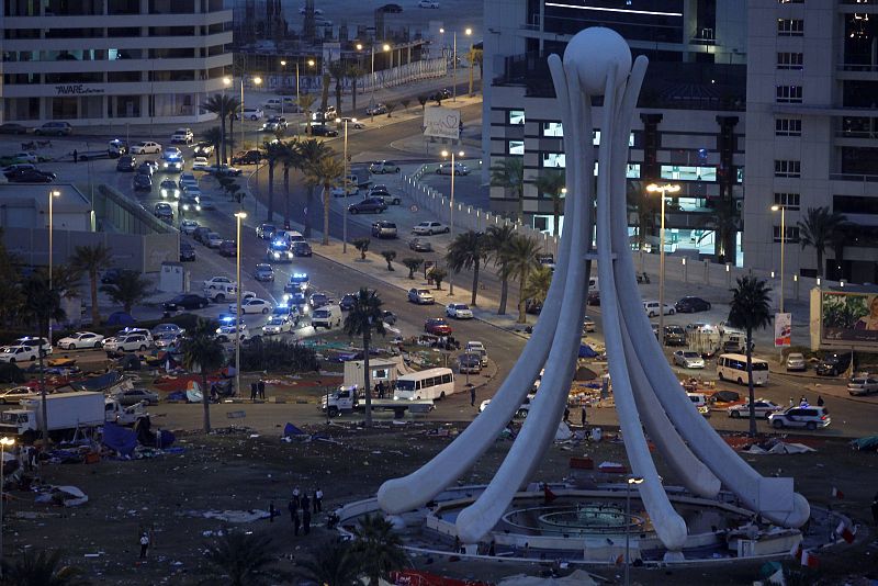 Coches de policía antidisturbios se acercan a la plaza de la Perla de Manama para dispersar a los manifestantes acampados.