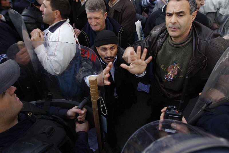 Protesters chant slogans in front of a policeman during a demonstration in Algiers