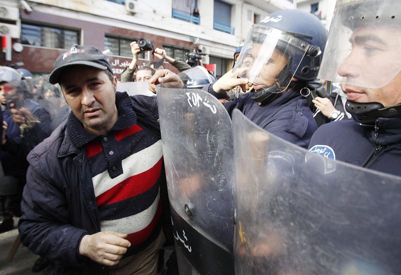 A protester is in a scuffle with a policeman during a demonstration in Algiers