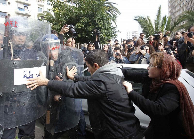 Protesters chant slogans and push policemen during a demonstration in Algiers